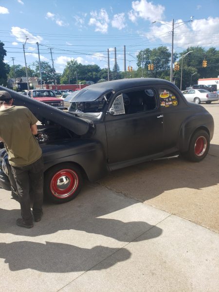 Black classic hot rod outside the shop